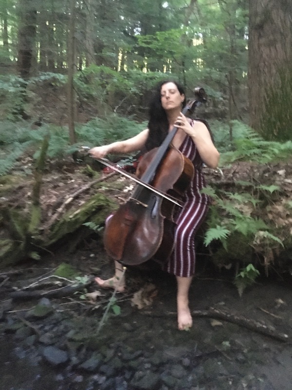 Rebecca Hartka playing cello in the woods